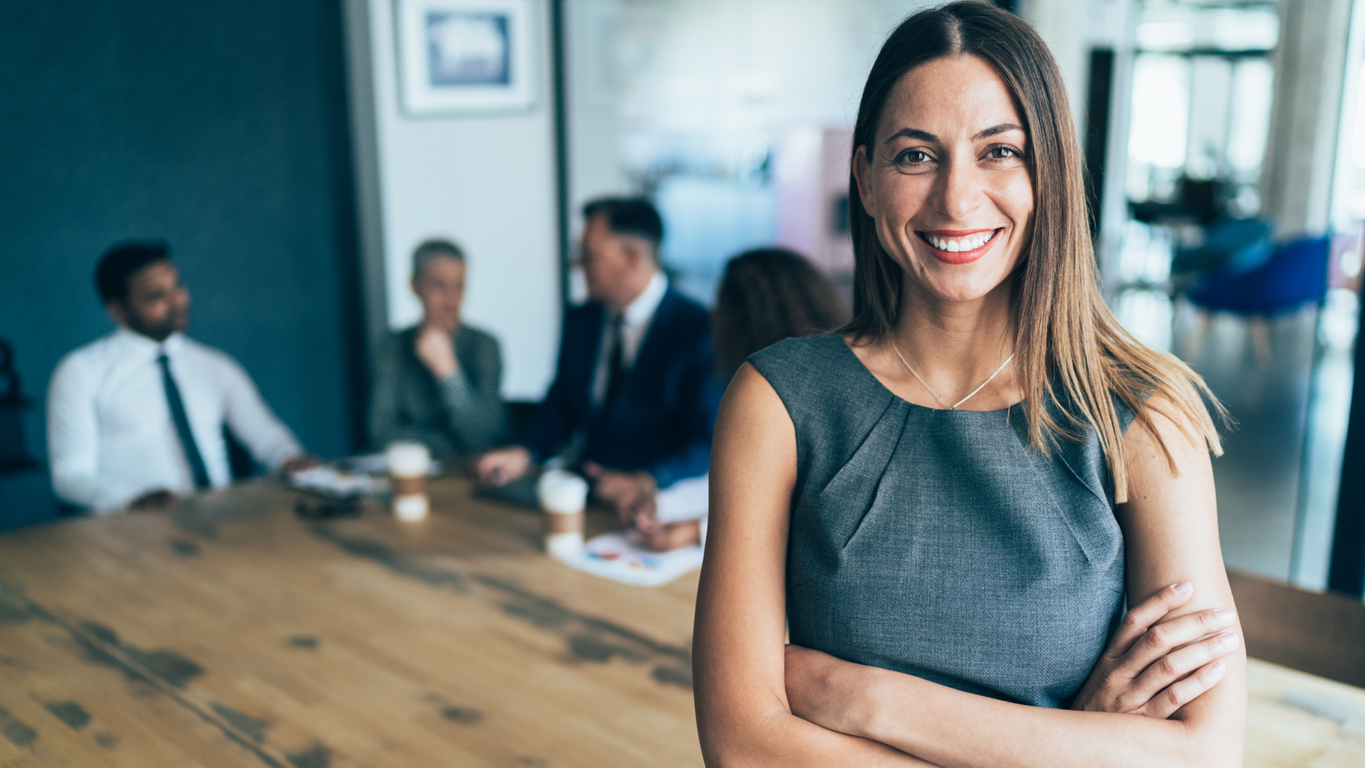 professional woman standing with people talking in the background