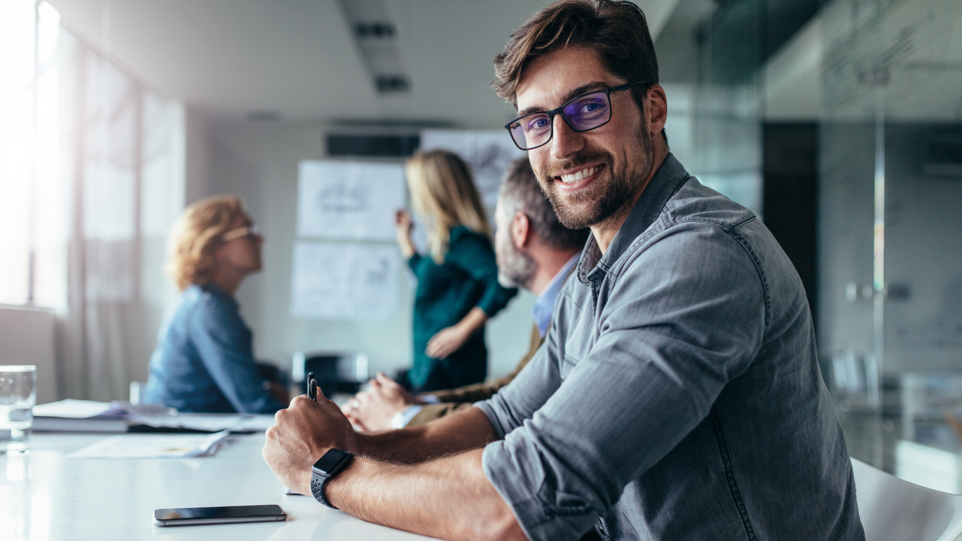 professional man looking ahead with people talking in the background